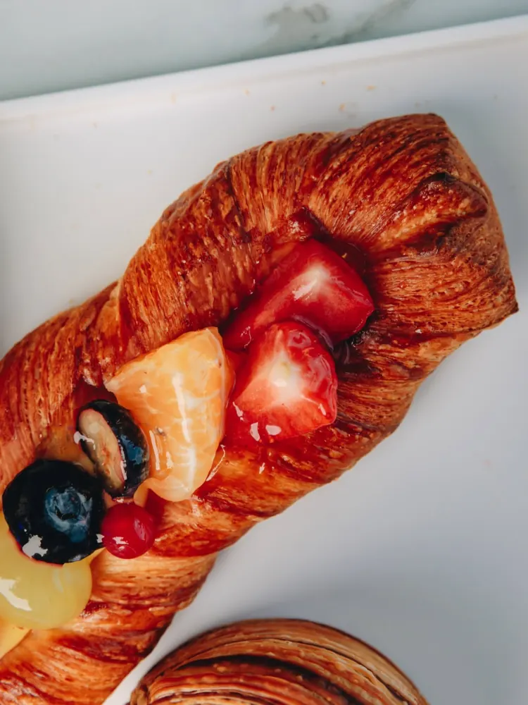 Sfogliato alla frutta fresca e croissant su un piatto bianco