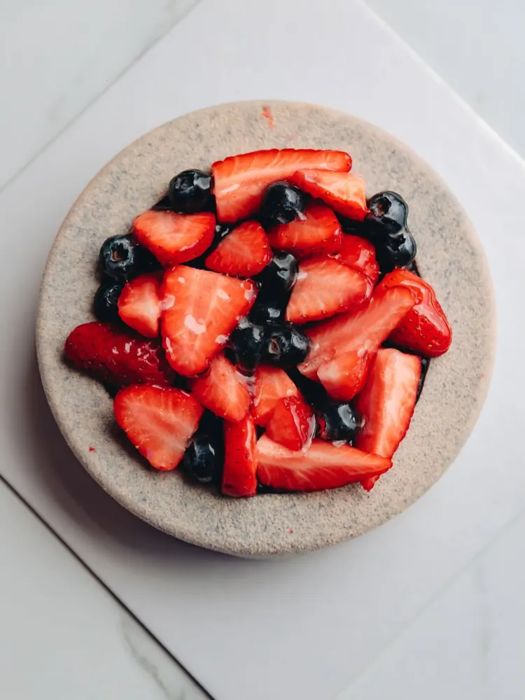 Torta moderna rotonda coperta di fragole e mirtilli freschi
